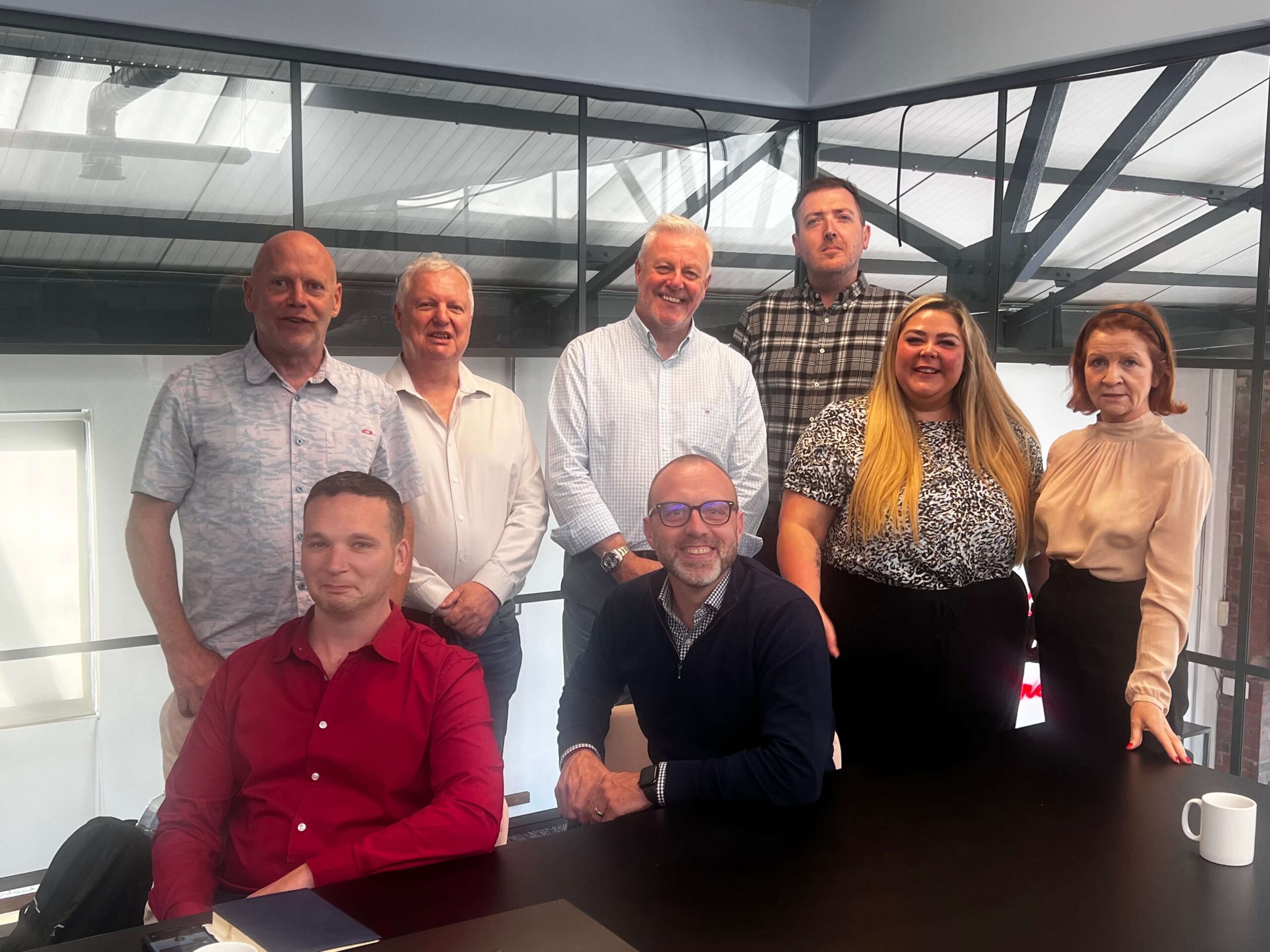 Athera Healthcare team team members smiling for the camera in one of their meeting rooms.